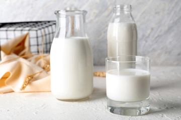 Glass and bottles of fresh milk on light table