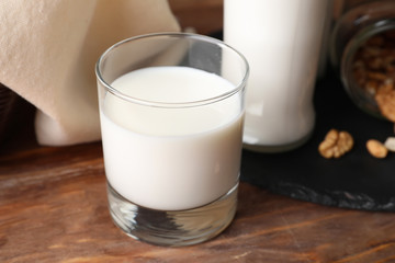 Glass of fresh milk on wooden table