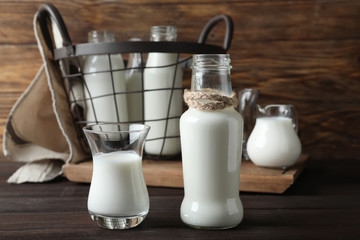 Glass and bottle of fresh milk on wooden table