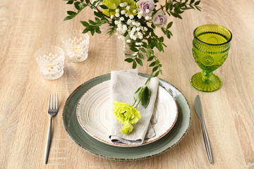 Beautiful festive table setting with floral decor on wooden background