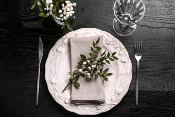 Beautiful festive table setting with floral decor on dark wooden background