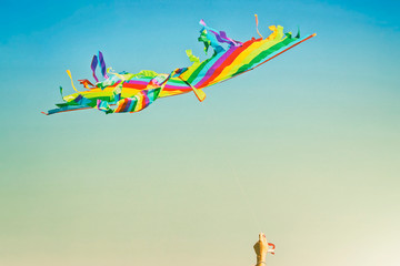 multi-colored kite flying on a blue sky background on a Sunny summer day