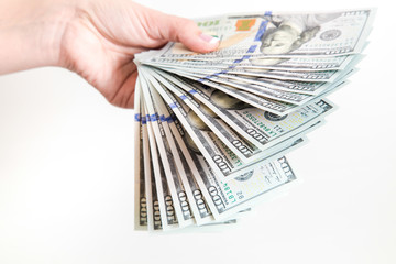 Closeup up view of white female hands holding many 100 dollars paper bills isolated on white...