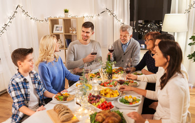 celebration, holidays and people concept - happy family having dinner party, drinking red wine and toasting at home