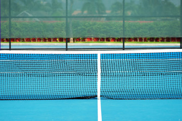Empty tennis court outdoors with net