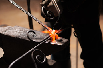 Blacksmith's Hand In Protective Gloves Solder A Metal
