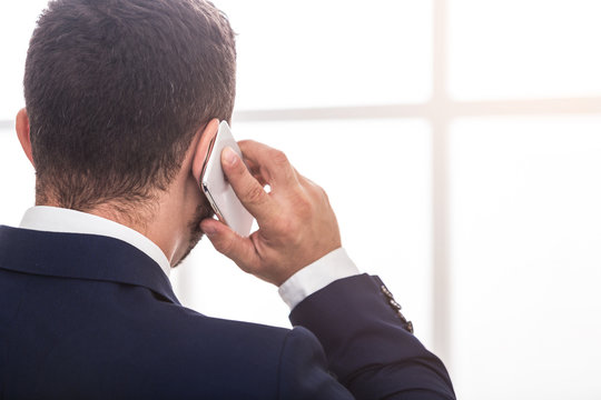 Businessman In Suit Talking On Mobile Phone, Back View