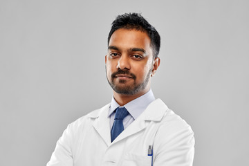 medicine, science and profession concept - indian male doctor or scientist in white coat over grey...