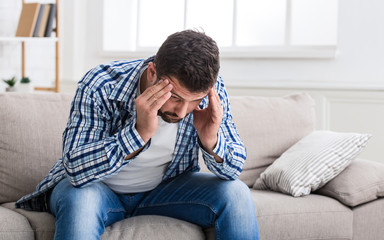Young man suffering from headache after hard working day