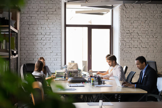Diverse employees busy working in shared office 