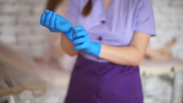 Gynecologist wears gloves. The doctor puts on sterile gloves.