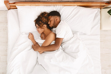 Loving couple sleeping in bed and hugging