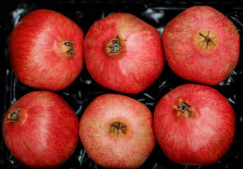 red granada fruit on a black background in the market