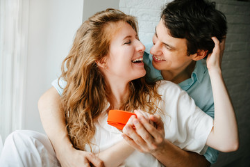 Couple in love watches a gift heart box on Valentine's day holiday.