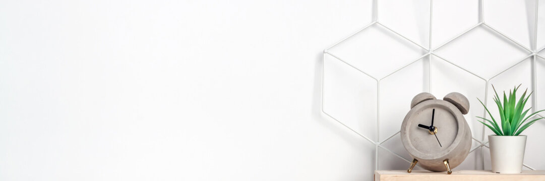 Creative hipster's desk at a white wall. Succulent, a concrete alarm clock and a metal graphic board - a toolbox. Panoramic copy space for text