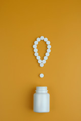 The exclamation mark of the pillsExclamation point. White pills on a yellow background. Important...