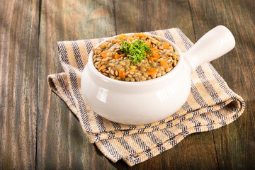 Lentil in ceramic bowl on rustic kitchen table background - Lens culinaris