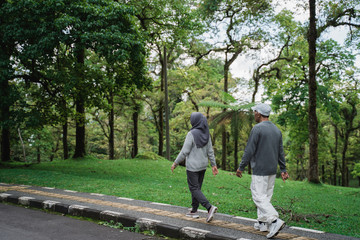 two senior couple walking together in the park doing som exercising