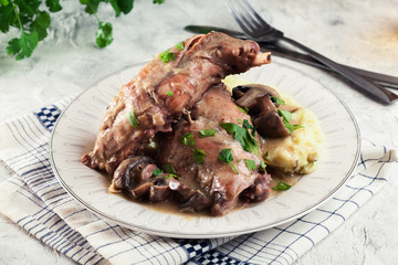 Stewed rabbit legs with vegetables