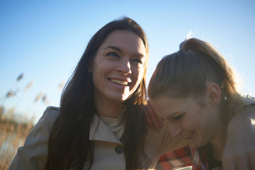 Portraits of a young lesbian couple enjoying their time together around a lake and jetty in winter sunshine