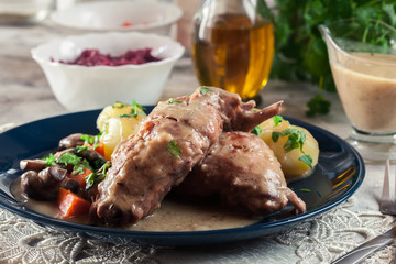 Stewed rabbit legs with vegetables