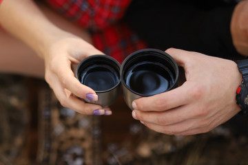 Fototapeta premium the girl and the guy drinking tea from a thermos