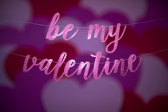 Be My Valentine message in glittering script hanging in a banner with abstract love heart overlay