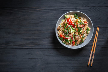 .Thai noodle wok with chopsticks on a black wooden background with a place for copy space