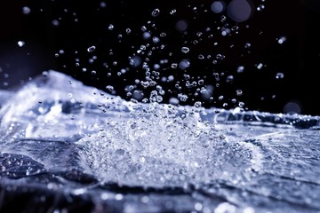 Water drops splashing on acoustic membrane. A lot of drops in air. High frequency of sound waves. Water cloud small drops. Frozen time shot.