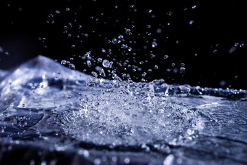 Water drops splashing on acoustic membrane. A lot of drops in air. High frequency of sound waves. Water cloud small drops. Frozen time shot.