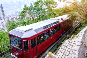 Naklejka na ściany i meble Victoria Peak Tram and unidentified people with Hong Kong city skyline background. landmark and destination for tourist attractions in HK