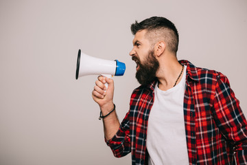 angry bearded man in checkered shirt screaming into megaphone, isolated on grey