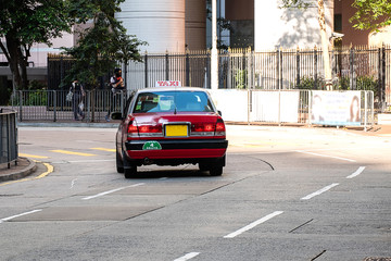 red and white colors Taxi cab, symbol of HK, on Hollywood road near Central and Sheung Wan district; Hong Kong, China, 16 December 2018