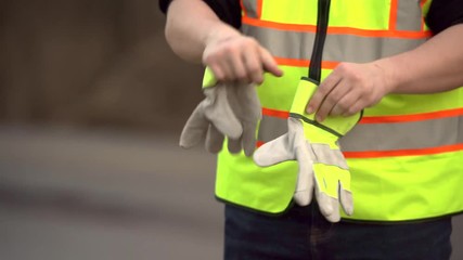 construction worker putting gloves on