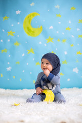 Little baby boy with cute teddy bear and moon on a blue star and moon background