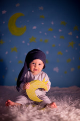 Little baby boy with cute teddy bear and moon on a blue star and moon background