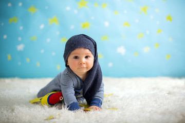 Little baby boy with cute teddy bear and moon on a blue star and moon background