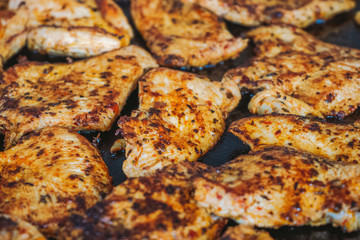 Closeup view of hot roasted grilled spicy chicken laying on frying surface. Horizontal color photography.