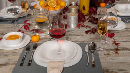 Rustic table setting with pink flowers and candle on light wooden table. Holidays decoration on Provence style. Romantic dinner. Overhead