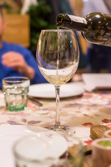Sommelier pours wine into a glass of restaurant guests at dinner
