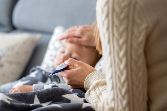 Sick Child, Toddler Boy Lying In Bed With A Fever, Resting At Home