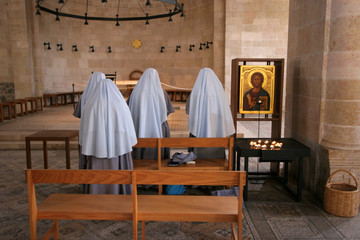 View of praying nuns inside The Church of the Multiplication of the Loaves and the Fishes, Tabgha, Israel
