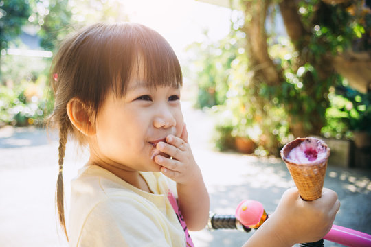 Cute happy baby girl are eating ice cream in summer. Picture for concept of sweet ,fat ,obesity and diabetes in children.