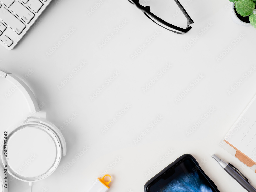 Poster top view of office desk work space with notebook, smartphone and gadget on white background with cop