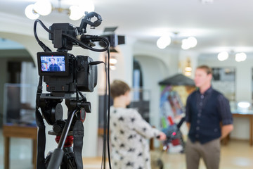 Video of the interview. Television equipment, camcorder with LCD screen, lighting equipment.