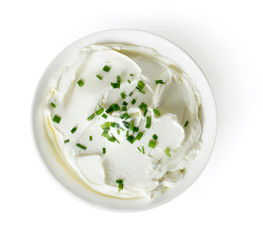 Cream cheese, quark or yogurt in a white bowl. Dairy product with fresh herbs, healthy eating theme. Isolated object on white background.
