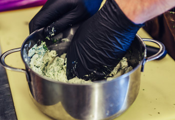 Male Chef Mixing Cut Dill with the Butter in the Steel Pot