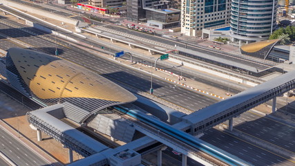 Futuristic building of Dubai metro and tram station and luxury skyscrapers behind timelapse