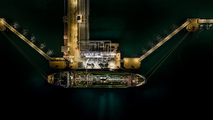 Tanker ship at the port, Oil terminal tanker ship loading at night, Aerial view.