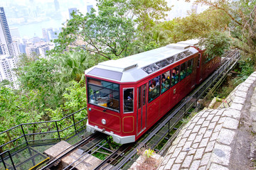 Naklejka premium Victoria Peak Tram and unidentified people with Hong Kong city skyline background. landmark and destination for tourist attractions in HK